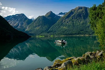  Hjelle, Norway: view of a fjord with montains and glaciers and a boat in foreground © A. Ciangherotti