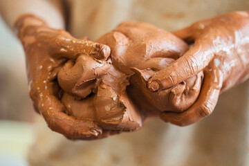 Detail of a ceramist woman's hands molding the clay