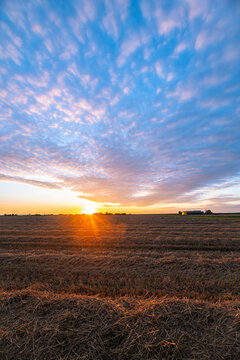 Altocumulus sheep clouds become beautifully colored as the sun sets over the countryside