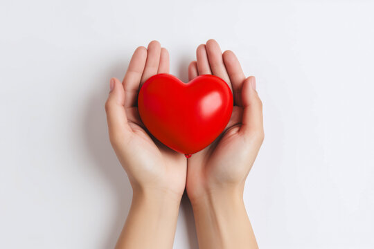 a pair of hands holding a red heart in white background