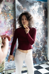 young beautiful woman posing in a red sweater in the studio