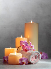Towels, orchid flowers, and burning candles.