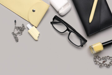 Stylish eyeglasses with stationery supplies and chain bracelets on grey background