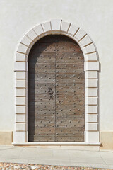 Detail, of a wooden gate ornately decorated with iron rivets, on a building in Tuscany, Italy.