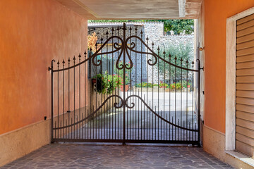 Beautiful ornate wrought iron gate in a backyard in Tuscany, Italy.