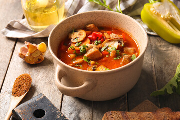 Pot of tasty beef stew on wooden background