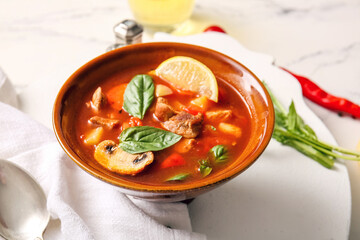 Bowl of tasty beef stew on table