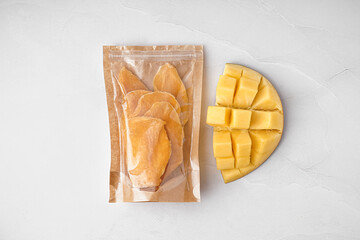 Package with slices of dried mango on white background