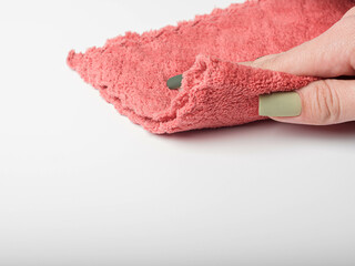 a woman holds a pink rag and wipes the surface of a table, wall or floor. Close-up. Empty space for text or logo. White background