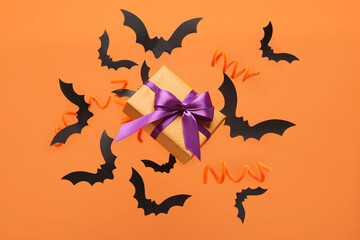 Flying gift box and Halloween decoration on orange background