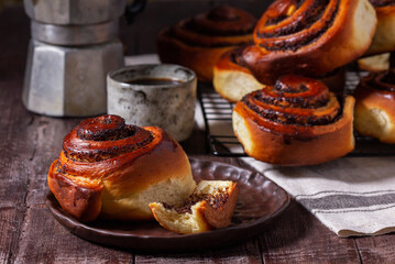 Yeast dough cinnabons with poppy seeds, raisins and candied fruits, served with coffee. Rustic style. - 647403898