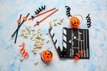 Movie clapperboard, popcorn and Halloween decor on blue grunge background