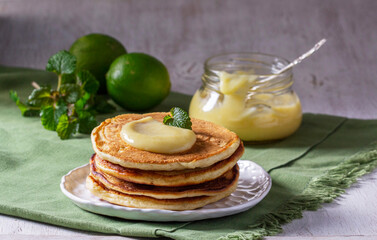 Whole grain flour fritters served with lime curd on a light background. Rustic style.
