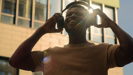 Happy smiling African American man joyful smile guy male put on wireless headphones earphones...
