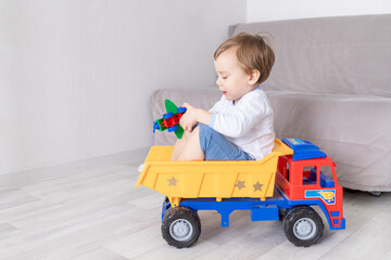 happy baby boy playing at home, riding in a typewriter, the concept of a child's game