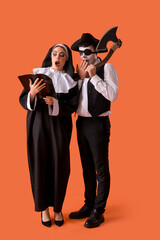 Young couple in costumes for Halloween party with Holy Bible on red background