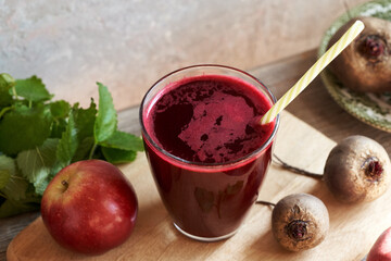 A glass of red beet juice with fresh apples and beetroot