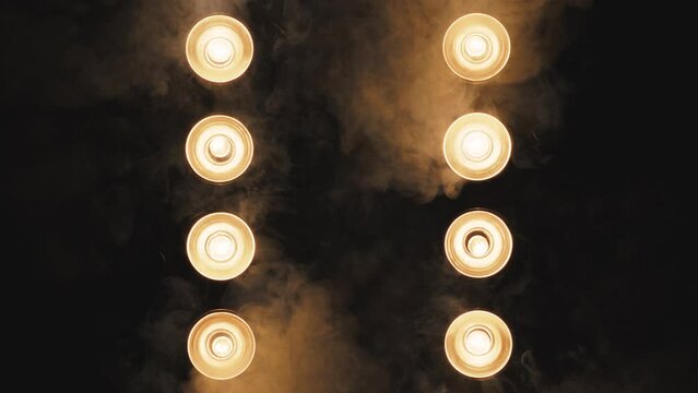 Yellow glow of spotlights in smoke