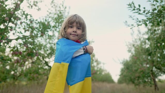 Handsome little boy - Ukrainian patriot 4 years old child holding national yellow blue flag on clear sky backdrop. Ukraine, peace, independence, freedom, future generation.