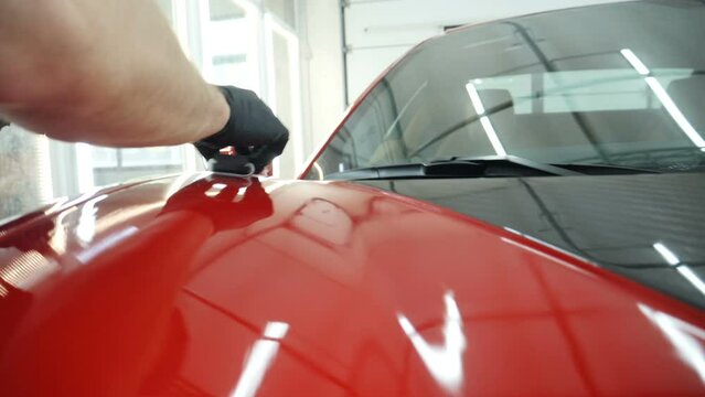 Staff wear Chemical protective clothing at work. Automobile industry. Car wash and coating business with ceramic coating.Spraying the varnish to the car. Concept of: Car protective, Service, Shine.	
