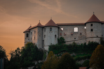 Beautiful Zuzemberk castle lit by evening sun in lat summer. Nice medieval castle in dolenjska region of slovenia, waiting to be rebuilt, rising above krka river.