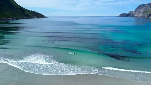 Surfers padling in the ocean drone flyby. Sailboat and beautful nature. 