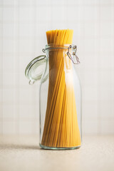 Spaghetti pasta. Uncooked italian pasta in glass bottle.