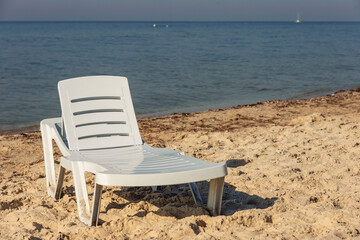 white plastic lounger on the background of the sea