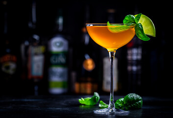 Spring grass alcoholic cocktail drink with scotch whiskey, apple liqueur, ginger, lemon juice, basil and ice, dark bar counter background