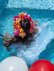 Femme habillée avec une couronne de fleurs dans la piscine  