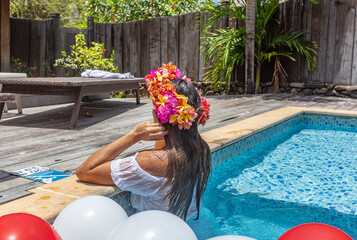 jolie femme avec une couronne de fleurs dans une piscine privée 