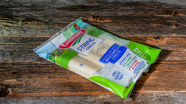 NORWALK, CT, USA - AUGUST 24, 2023: Mozzarella string cheese from Galbani brand on rustic wooden  table