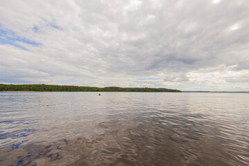 Beautiful view of lake surface merging with cloudy sky on horizon. Uppsala, Sweden, Europe.