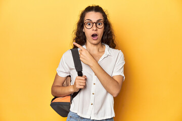 Caucasian university student with glasses, backpack, pointing to the side