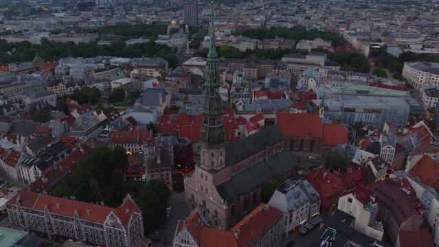 High angle view of historic town centre at dusk. Aerial shot of old buildings and narrow streets around St. Peters Church. Riga, Latvia