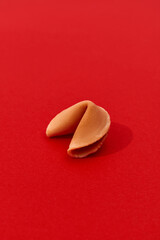Fortune cookie on a red background with deep long shadow. Background template for restaurant