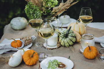 Fall decoration rustic style, cozy home atmosphere , candles, dry flowers. Autumn elegant beautiful table setting with pumpkins for a wedding or thanksgiving celebration