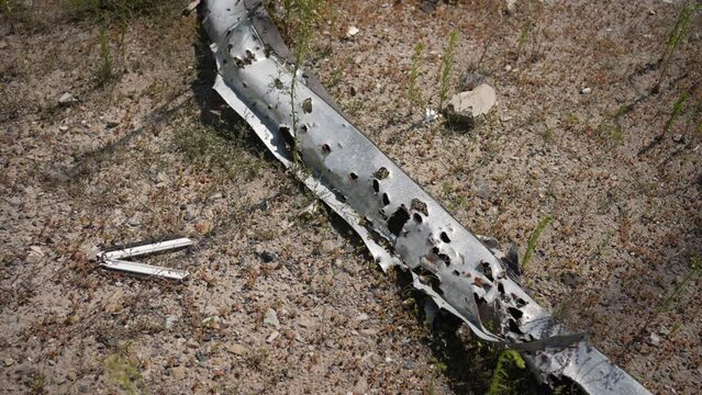 An iron spare part of rural machinery is pierced by bullets