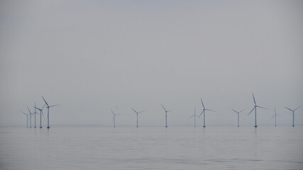 Farma turbin wiatrowych we mgle na morzu