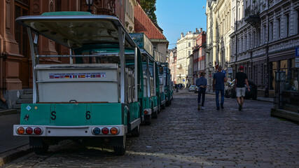 Zielona kolejka turystyczna czeka na przewóz pasażerów po starym mieście miasta Ryga na Łotwie - obrazy, fototapety, plakaty