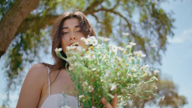 Sensual girl proposing bloom at rural nature portrait. Woman enjoying flowers