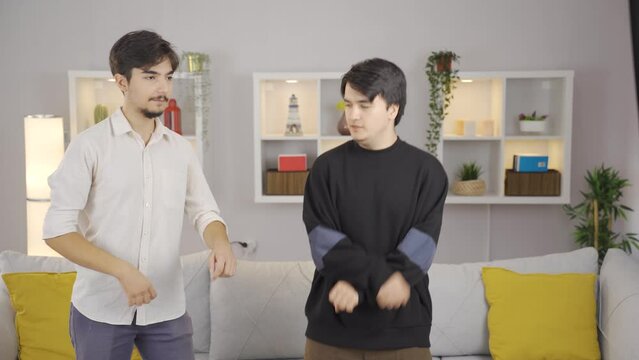 Friends dance funny and witty together at home.