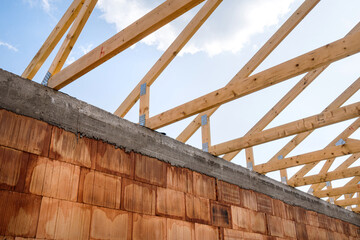 Roof under construction with wooden support beams and ceilings connected together with metal joints