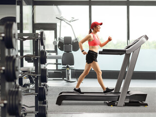 Fototapeta premium Female exercising on a treadmill at the gym