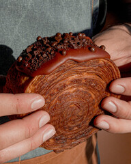 Delicious round croissant with bitter chocolate coating, luxury pastries