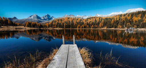 panorama landscape of mountain lake in the Swiss Alps with reflections and autumn colors