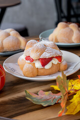 Delicious traditional mexican pan de muerto, filled with delicious cream, with red fruits inside, strawberries and blackberries.