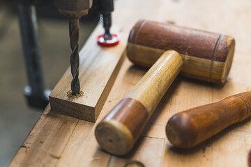 Carpenter tools, a drill and a mallet on wooden working bench. High quality photo