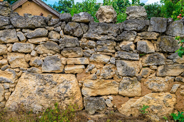 Old rustic fence made of stones collected without mortar. Background with selective focus