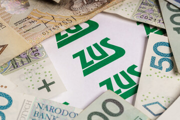 the inscription "ZUS" surrounded by Polish PLN banknotes and zlotys (selective focus)